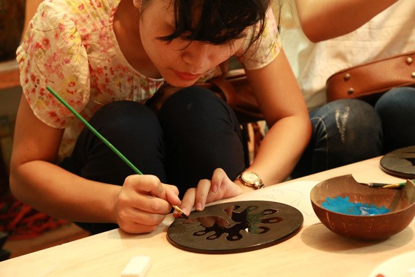 artisanne peint l'assiette au village metier a hanoi